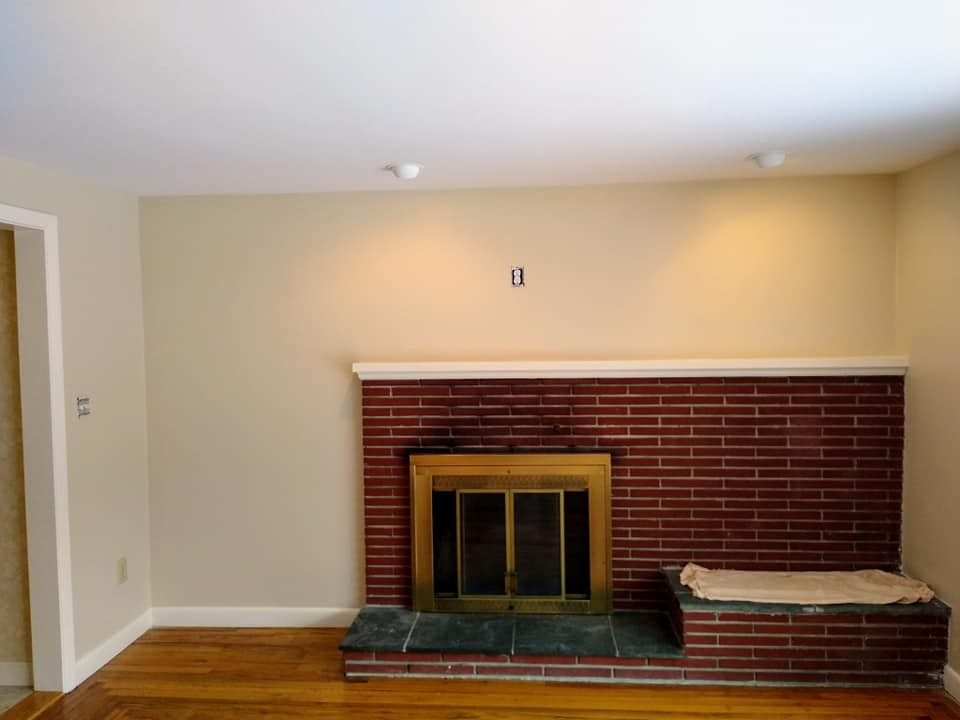 Empty living room with fireplace repainted by Genesis Painting
