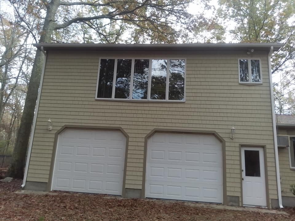 Garage and home on a wooded lot serviced by Genesis Painting